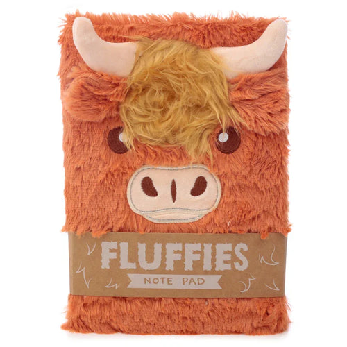 Front view of a fluffy, brown A5 notebook, depicting a Highland coo cow with light horns, shaggy orange hair, and an embroidered face. A paper band around the centre states 'FLUFFIES NOTE PAD'.