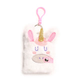Front view of a white fluffy unicorn notebook cover, featuring a golden glitter horn, pink glitter ears, embroidered purple eyes and pink cheeks, and a pink glitter strap. A silver keyring and pink plastic clip are attached at the top.