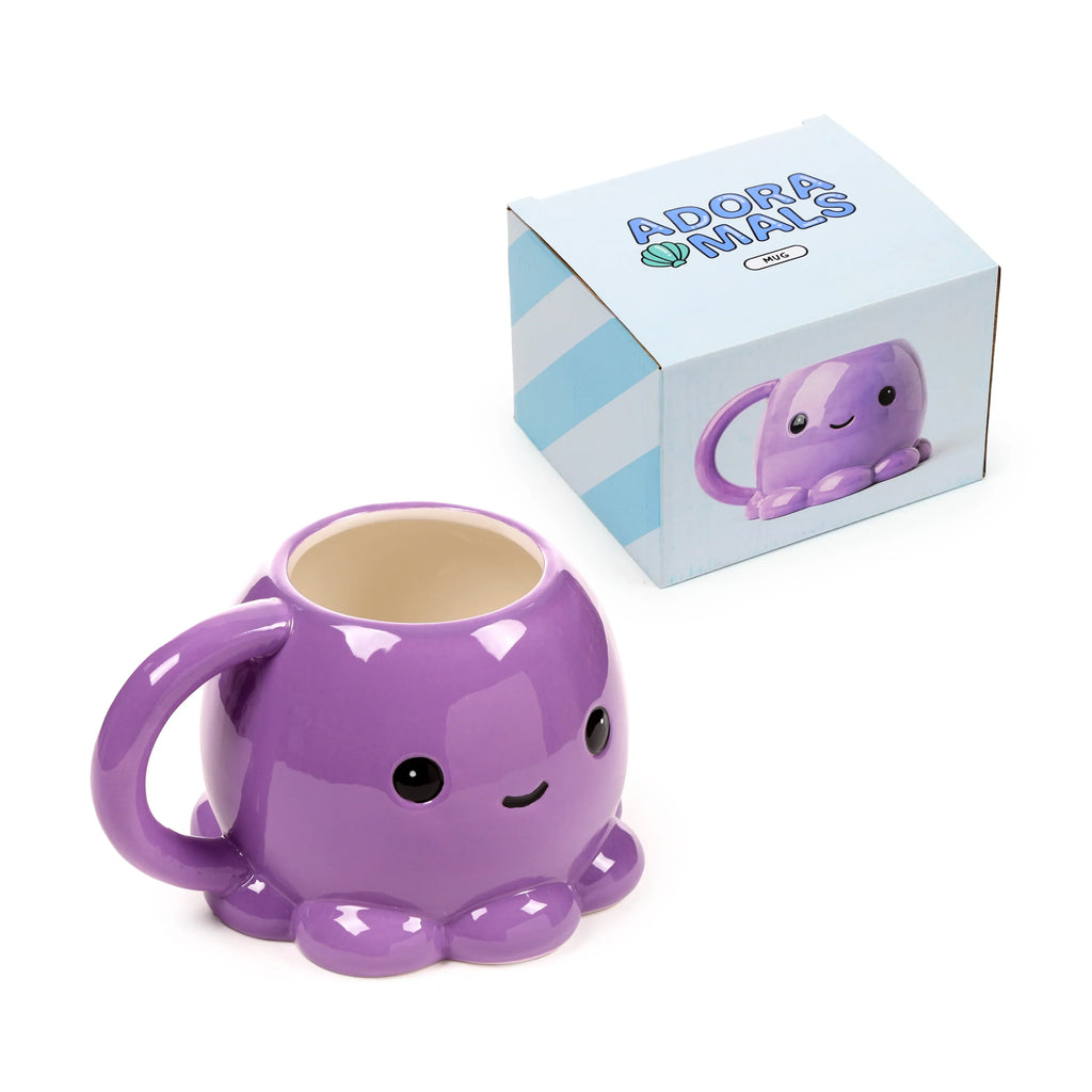 Angled view of an Adoramals purple ceramic octopus head shaped mug, featuring black eyes, a smiling mouth, and tentacles forming its base, displayed next to its light blue and white product box.