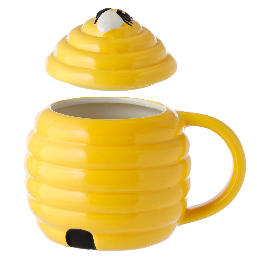 Yellow beehive-shaped ceramic mug with handle and black entrance detail, its matching lid with a bee motif shown floating above the mug's open white interior.