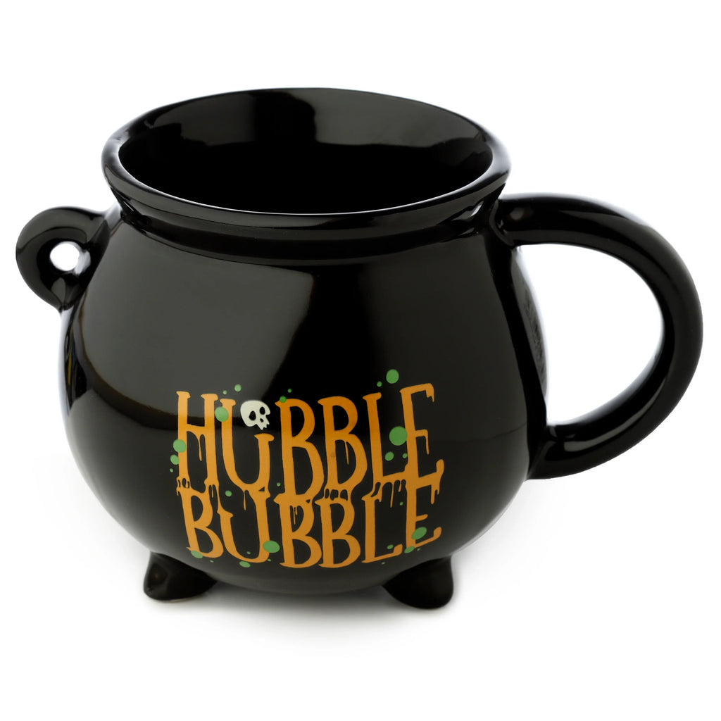 Angled view of a black ceramic cauldron-shaped mug, featuring orange 'HUBBLE BUBBLE' text with a small white skull and green splatters, a main handle, a decorative loop, and three base feet.