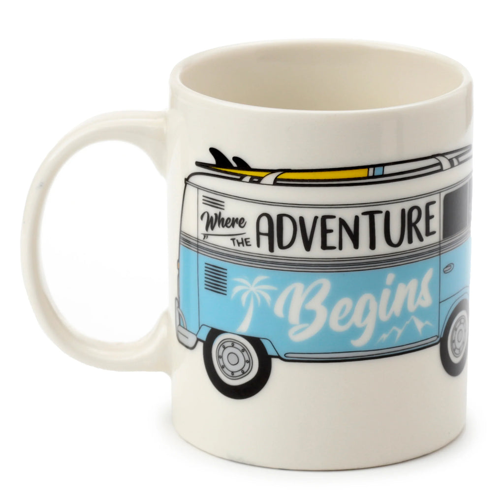 Angled view of a porcelain mug featuring a light blue Volkswagen T1 campervan design with surfboards on its roof and 'Where The Adventure Begins' text.