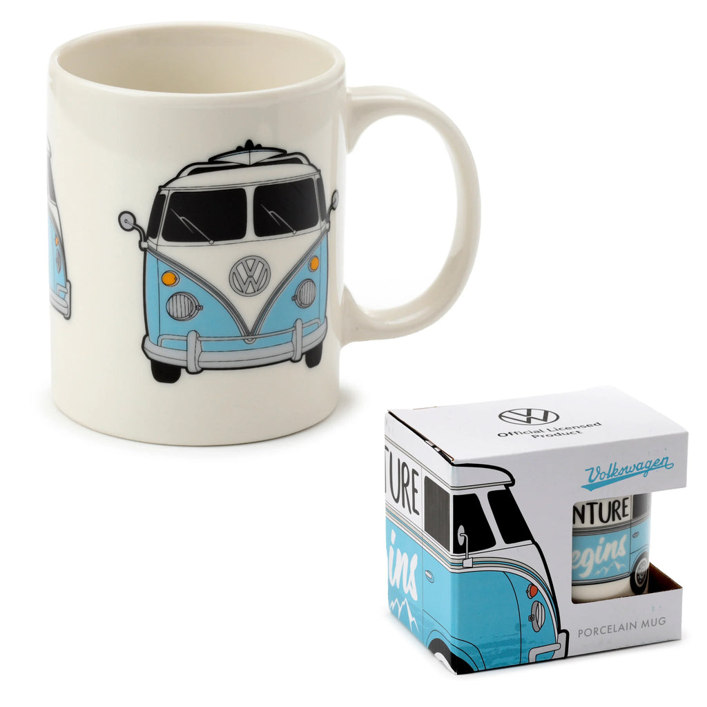 Angled shot of a cream porcelain mug with a blue and white VW T1 Camper Bus illustration, including the VW logo, next to its coordinating blue and white product box.