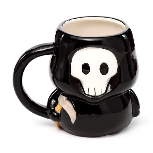 Angled view of a black ceramic novelty Skull Boy mug, featuring a white skull face, a black handle, and a small scythe detail.