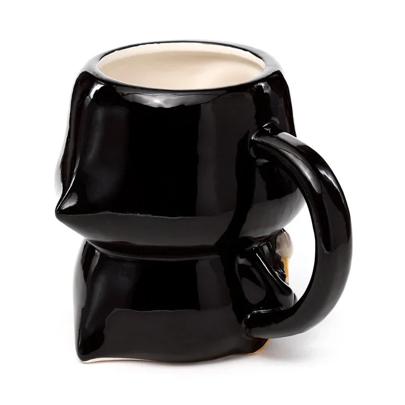 Angled view of a glossy black ceramic Skull Boy novelty mug, showing its distinctive rear design, robust handle, and light-coloured interior.