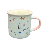 Angled view of a pale blue porcelain fine rimmed mug with a pink handle and rim, decorated with white unicorns, rainbows, stars, hearts, and flowers.