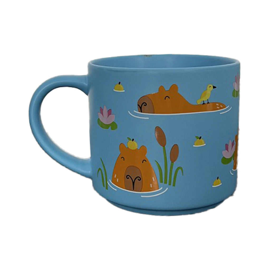 Large blue porcelain capybara mug, shown from an angle, featuring two capybaras swimming in water with a bird, cattails, and pink water lilies.
