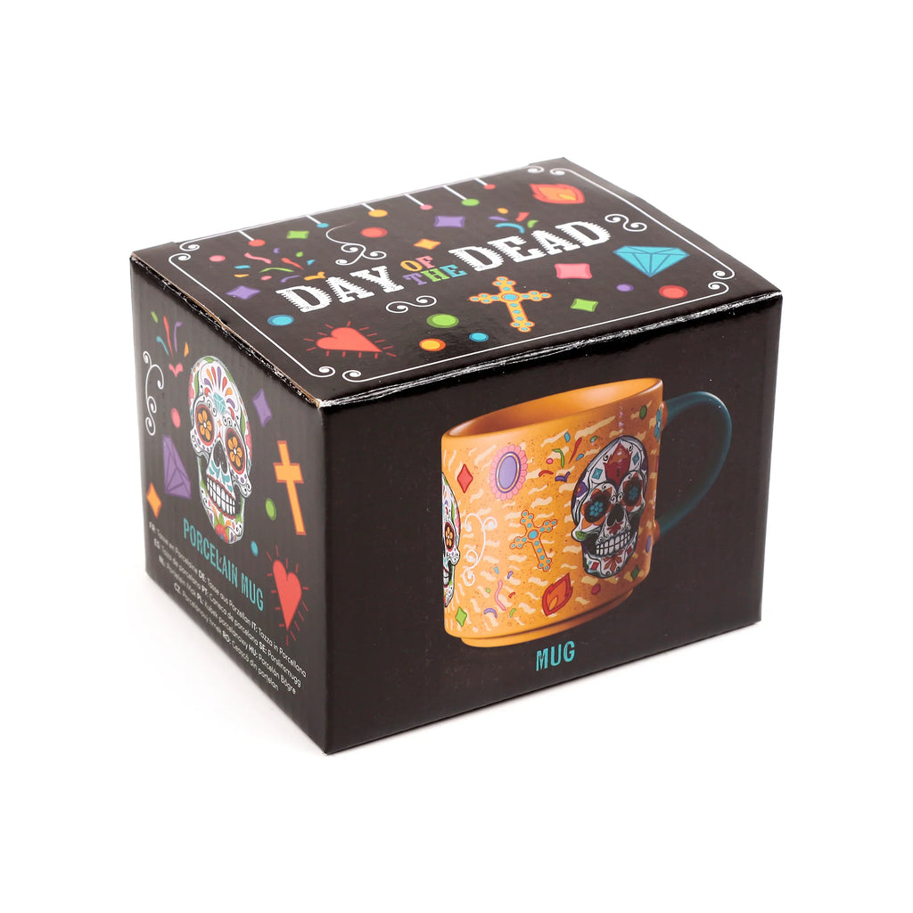 Angled view of a black packaging box for a large Day of the Dead porcelain mug. The box features colourful sugar skull, cross, and festive confetti patterns, and displays an image of the orange mug with a skull design and blue handle.