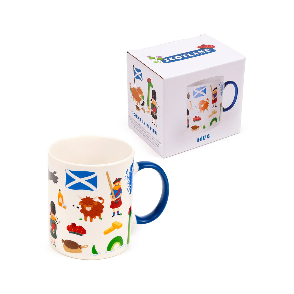 Angled view of a white porcelain Scotland souvenir mug with a dark blue handle, decorated with colourful cartoon illustrations including the Saltire flag, a Highland cow, a bagpiper, and the Loch Ness Monster. A matching gift box is visible behind it.