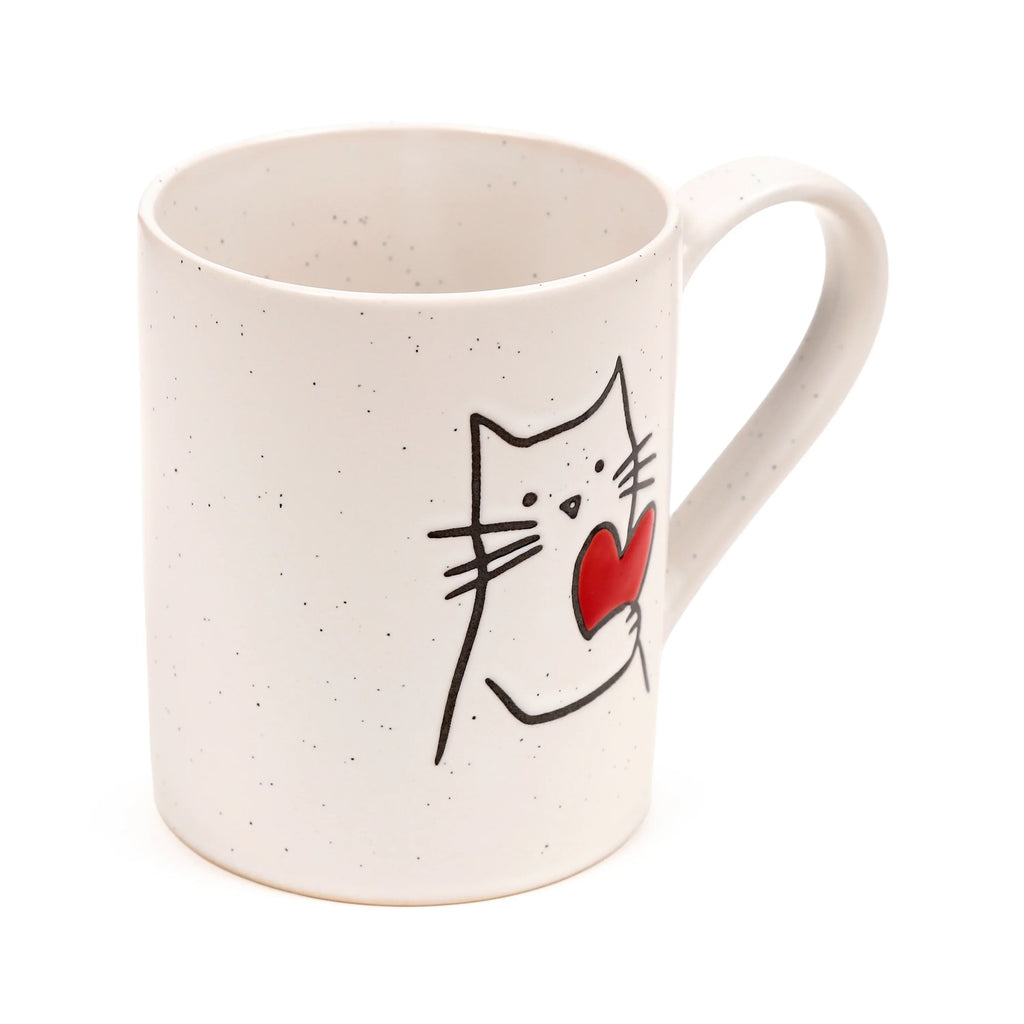 Angled view of a speckled cream stoneware mug, depicting a black outline cat holding a red heart, with its handle visible.