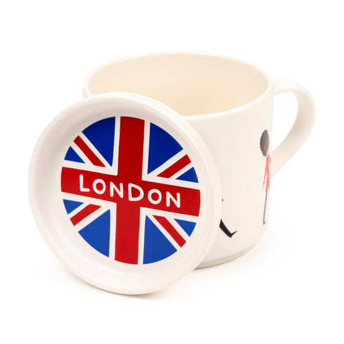 Off-white porcelain mug with a partial London Guardsman illustration, paired with a matching coaster lid displaying a Union Jack flag design and 'LONDON' text, angled view.