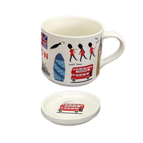 Angled view of a white porcelain mug with handle, featuring colourful London souvenir illustrations including a Union Jack, Beefeaters, and a red double-decker bus. A matching round coaster with a red double-decker bus design is placed below.