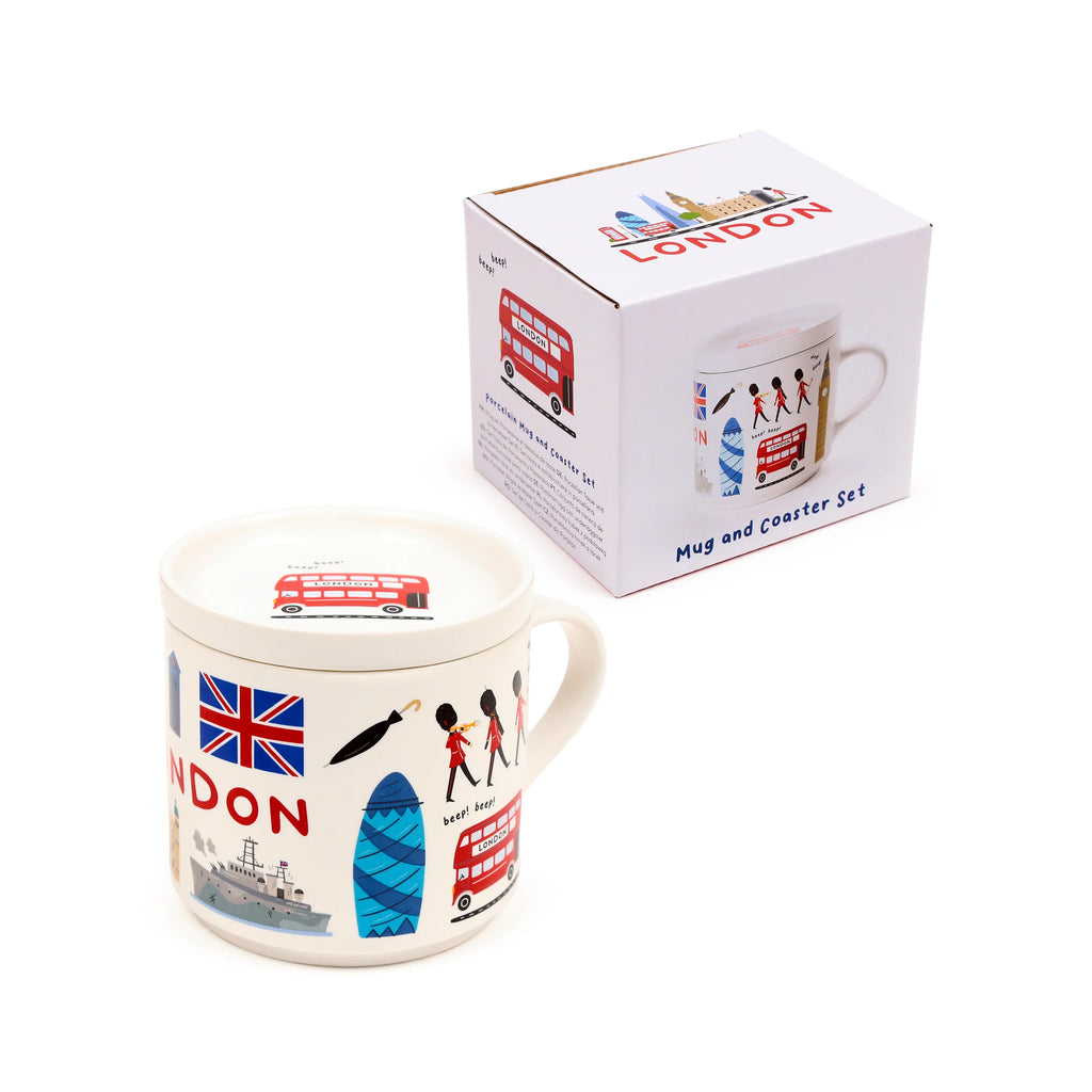Angled view of a white porcelain mug with a matching coaster lid, both decorated with colourful London illustrations including a Union Jack, red double-decker bus, and Queen's Guards. The set is shown with its white retail box.