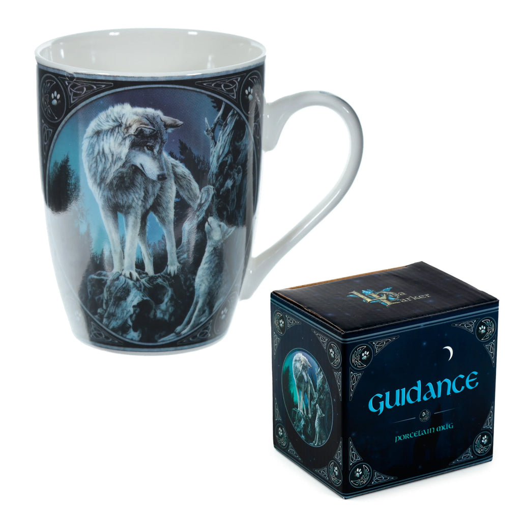 Angled view of a white porcelain mug featuring a 'Guidance' wolf design with a large grey wolf, a smaller wolf pup, and Celtic knot borders. A matching dark blue gift box is visible beside the mug.