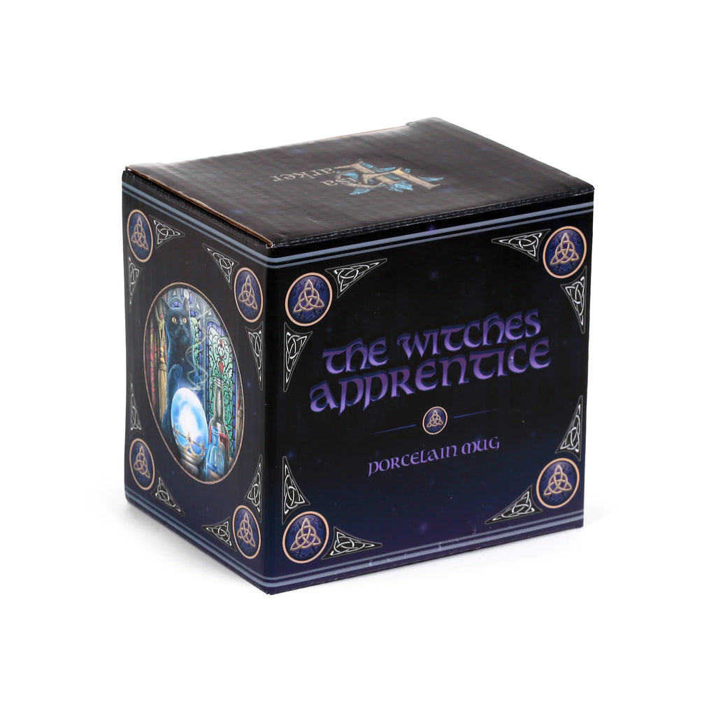 Angled view of a dark navy porcelain mug gift box. One side features purple text 'the witches apprentice' and 'porcelain mug'. The adjacent side displays an illustration of a black cat peering into a crystal ball with a stained-glass background. The box is decorated with gold and white Celtic knot symbols.