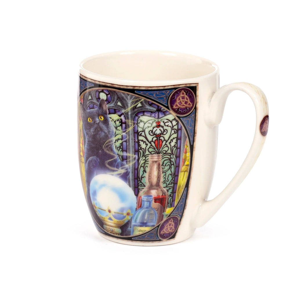 Off-white porcelain mug showcasing the Lisa Parker 'Witch's Apprentice Cat' design, featuring a black cat, a glowing crystal ball, and potion bottles set against a colourful stained-glass window, with intricate Celtic knotwork framing, presented from an angled view revealing the handle.