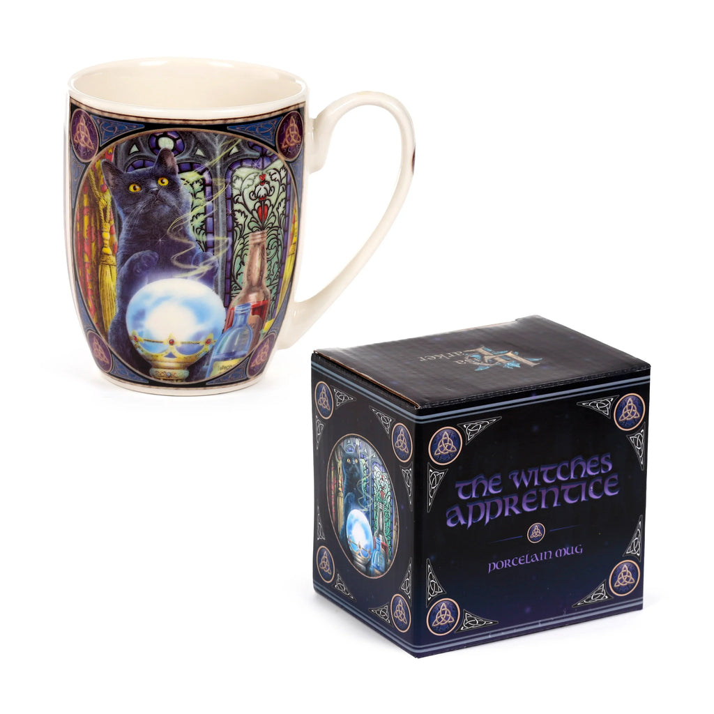 Angled view of a cream porcelain mug, depicting a black cat with a crystal ball against a stained-glass background, alongside its dark packaging box featuring 'The Witch's Apprentice' text and matching cat artwork.