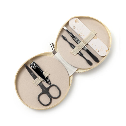 An overhead view of an open, round, beige zipped manicure set case, neatly displaying six metal manicure tools including scissors, nail clippers, tweezers, two different cuticle tools, and a cream-coloured nail file with brown speckles, all held securely by elastic straps.