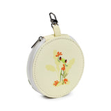 Angled view of a round, cream-coloured manicure set, adorned with a colourful tropical frog illustration in green and orange, featuring a silver-coloured zip and carabiner clip.