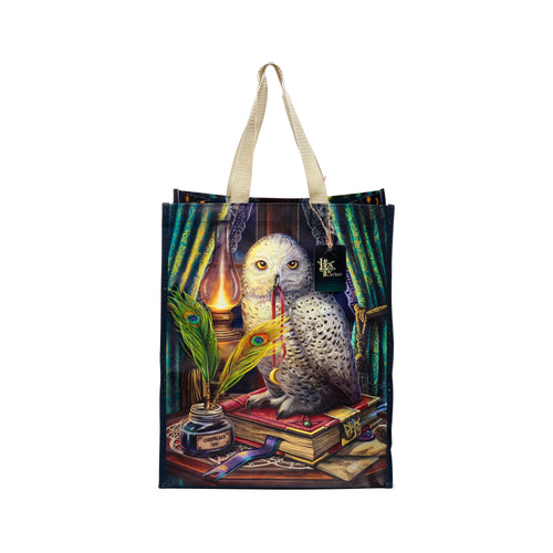 Front view of a reusable shopping bag with an illustrative design of a white owl perched on books, beside an oil lamp, inkwell, and peacock feather quills, with beige carrying handles.