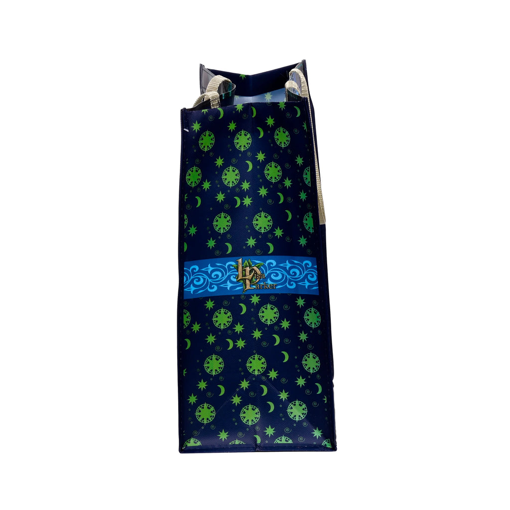 Angled view of a dark blue reusable shopping tote bag with a green moon, star, and compass pattern, featuring a Lisa Parker logo and cream-coloured handles.