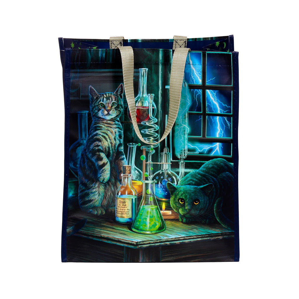 Front view of a durable reusable shopping tote bag, featuring a detailed artwork of two cats in a dark, atmospheric laboratory. A tabby cat sits upright near an Elixir Dr Jekyll bottle and other science flasks with colourful liquids, while a dark cat crouches low, its eyes glowing. Blue lightning streaks across a window in the background, and the bag has light-coloured woven handles.