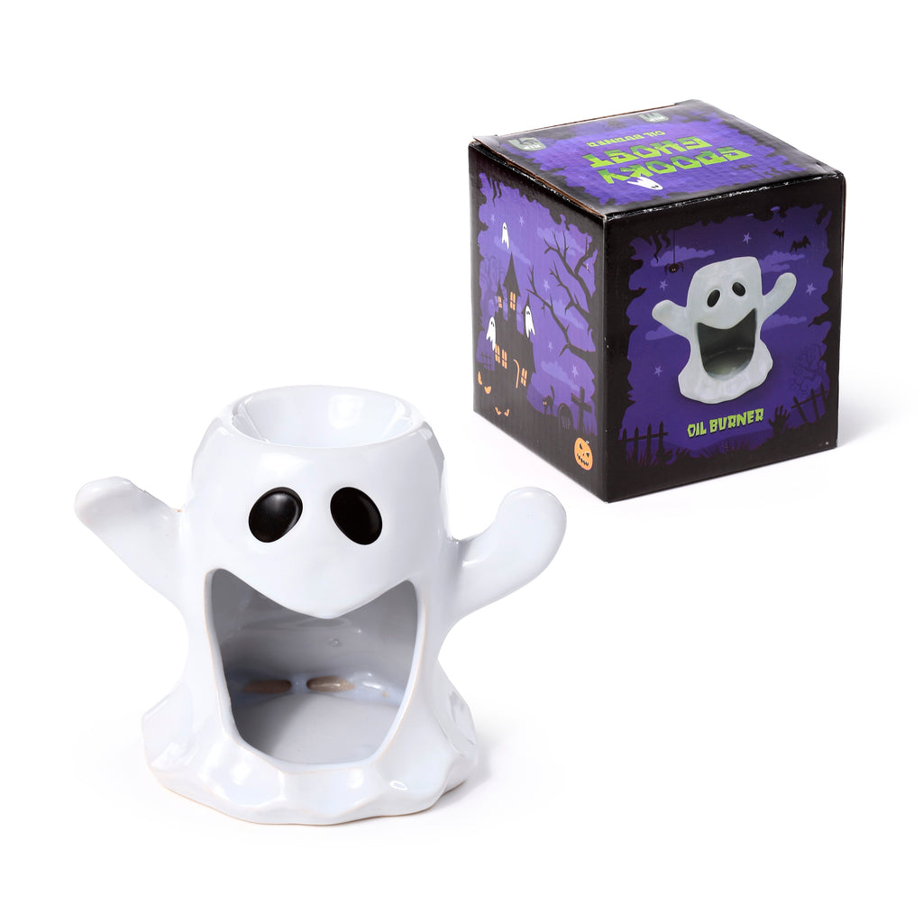 Front view of a glossy white ceramic ghost-shaped oil and wax burner with black eyes and an open mouth, positioned alongside its purple and black packaging box featuring a haunted house design.