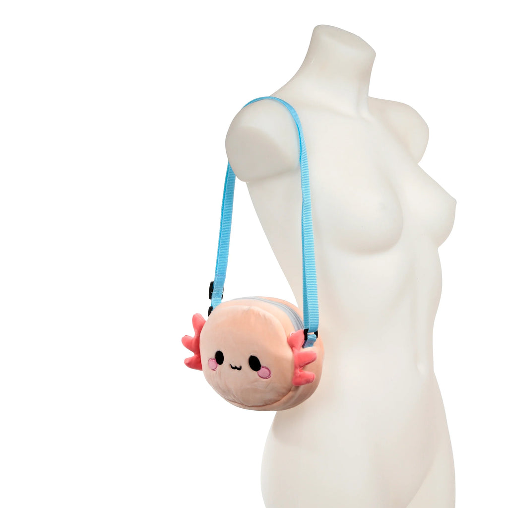 In-context lifestyle shot showing the front of the Adoramals Maddie the Axolotl plush crossbody bag, pale pink with embroidered features and pink gills, and a light blue adjustable strap, modelled on a white mannequin torso.