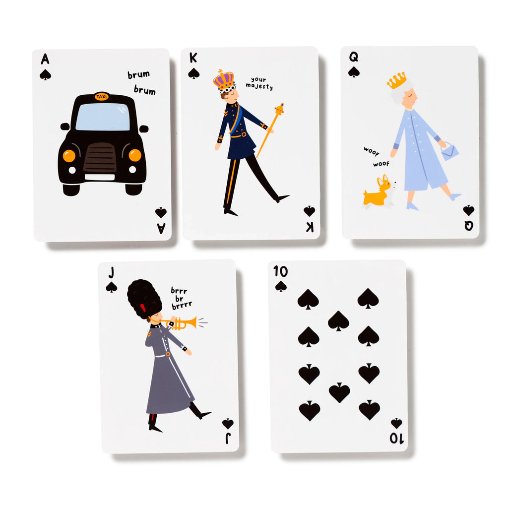 Five London souvenir playing cards from the spades suit, displayed face-up on a white background. Visible are the Ace featuring a black taxi, the King with a crowned royal figure, the Queen with a queen and corgi, the Jack showing a royal guard playing a trumpet, and the Ten of Spades with traditional pips.