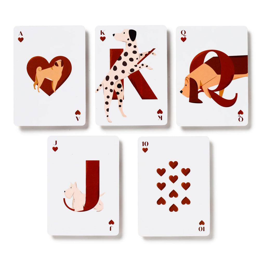Overhead view of five white dog-themed playing cards from the Hearts suit, laid out face up. The Ace, King, Queen, and Jack cards feature unique stylised illustrations of different dog breeds, including a pug, dalmatian, basset hound, and terrier. All five cards display red heart symbols.