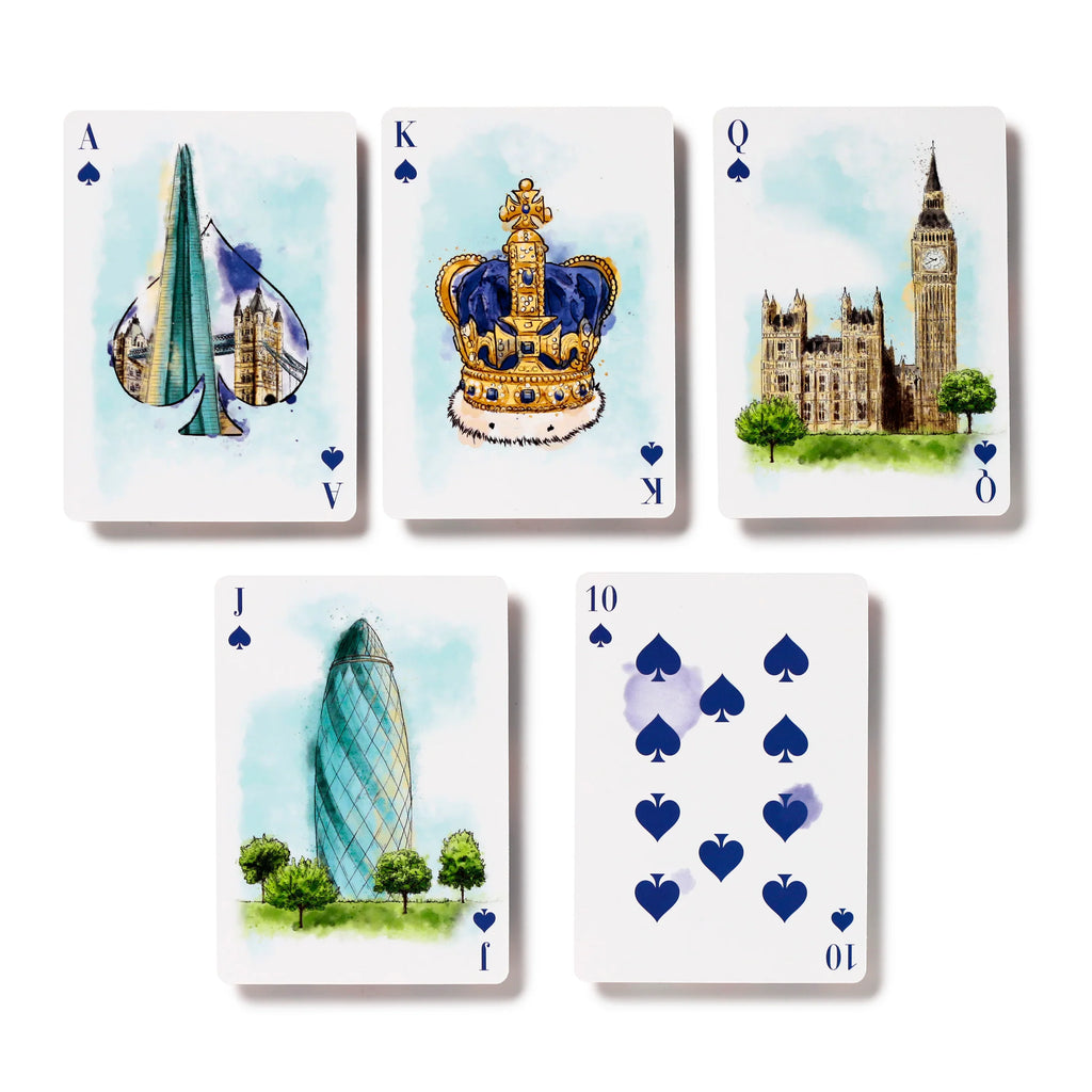 Overhead view of five white playing cards, including the Ace, King, Queen, Jack, and Ten of Spades. The cards feature watercolour illustrations of London landmarks such as The Shard, a royal crown, the Houses of Parliament with Big Ben, and The Gherkin building, laid out on a white background.