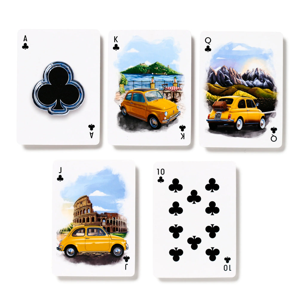 Overhead view of five playing cards from a Fiat 500 deck, showcasing the Clubs suit: Ace, King, Queen, Jack, and 10. The Ace features a metallic-effect black club symbol. The King, Queen, and Jack cards display illustrations of a yellow Fiat 500 in scenic landscapes, with the 10 showing ten black club pips.