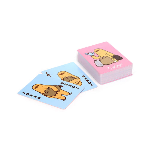 Angled overhead view of a stack of pink-backed Pusheen the Cat playing cards, featuring a long, light brown creature with a blue bird and other small animals. Two light blue Joker cards, each showing the long, light brown creature holding Pusheen, are laid out in front.