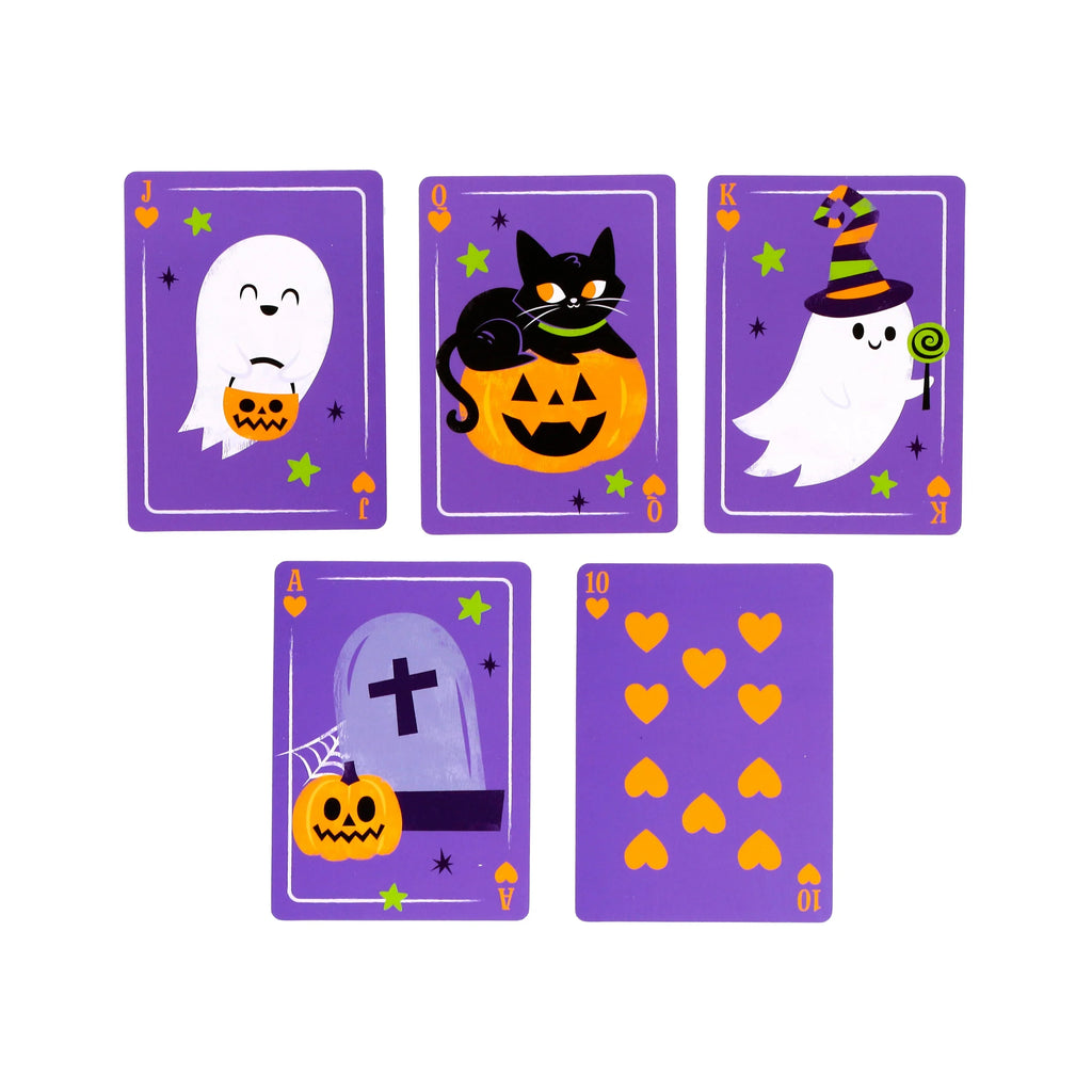 Flat lay of five spooky-themed playing cards: a Jack with a ghost and pumpkin basket, a Queen with a black cat on a pumpkin, a King with a ghost in a witch's hat, an Ace with a tombstone and pumpkin, and a Ten of Hearts. All cards are purple with orange and green details.