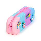 Angled view of a pink, blue, and purple ombre silicone pencil case with a pink zip, decorated with colourful silicone charms including a unicorn head, a shooting star, and a rainbow.