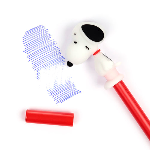 Angled top-down view of a red erasable pen with a white Snoopy character topper, positioned next to blue handwritten lines, some partially erased, and a red pen cap on a white surface.