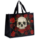 Angled view of a black reusable shopping bag made from recycled plastic bottles (RPET), with black handles. The bag features a detailed gothic design of a light-coloured skull surrounded by vibrant red roses, green vines, a moth, and a bird.