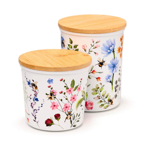 Angled view of a set of two white recycled RPET storage jars, one larger and one smaller, with natural bamboo lids. Both jars feature a colourful pattern of wildflowers and bees.