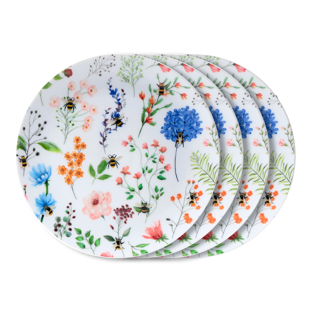 Angled view of four stacked white picnic plates, each decorated with a colourful Nectar Meadows floral and bee pattern.
