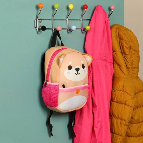 Front view of a Kids School Neoprene Backpack featuring an Adoramals Shiba Inu dog design with pink accents, hanging on a colorful coat rack.