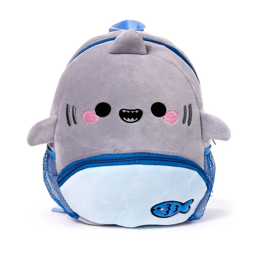 Front view of a plush grey and light blue kids school rucksack shaped like a cartoon shark, featuring an embroidered face, fins, blue zippers, mesh side pockets, and a blue fish design.