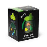Front and left side view of a black retail box showcasing a reusable shatterproof sippy cup. The box features an image of a green sippy cup with colourful orange, yellow, and green dinosaur illustrations. Text on the box indicates 'Sippy Cup with hygienic cover,' with a diagram on the left panel illustrating the hygienic cover.