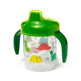 Angled view of a reusable, shatterproof sippy cup with a vibrant green lid and handles. Its clear body is adorned with colourful cartoon dinosaur illustrations, including red, yellow, and green characters.