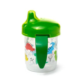 Front view of a reusable shatterproof sippy cup featuring a clear base with colourful dinosaur illustrations and a bright green lid and handle.