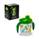Angled view of a translucent reusable sippy cup with a green lid and handles, featuring a colourful dinosaur print, displayed alongside its black product box detailing it as shatterproof and 'Dinosauria Jr'.