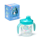 Angled view of a clear sippy cup with turquoise handles and lid, featuring a colourful unicorn, rainbow, cloud, heart, and star pattern. Its blue product box, decorated with similar designs, is visible behind it.