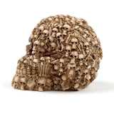 Side view of a Multiple Skulls Head Decoration figurine, an aged, bone-coloured skull ornament intricately formed from many smaller skulls and skeletal fragments.