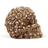 Multiple skulls head decoration ornament, bone-coloured, intricately detailed with smaller skulls and bones, angled view.