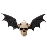 Front view of a gothic wall plaque depicting a bone-coloured skull with small horns and dark grey bat wings, featuring hollow eye sockets and textured wing membranes.