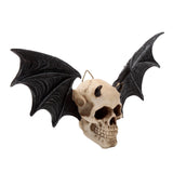 Cream-coloured Gothic wall plaque depicting a devil skull with empty eye sockets, prominent teeth, small dark horns, and pointed ears. Large, textured dark grey bat wings extend from either side. A gold-coloured hanging loop is visible at the top of the skull, shown from a slightly angled view.